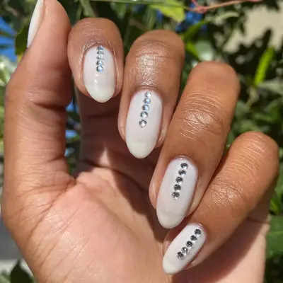 milky manicure with gemstones down the center