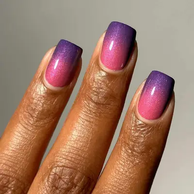 Manicured nails with a shimmery pink to purple ombre design