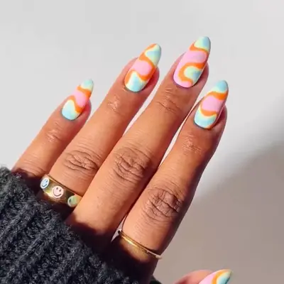Hand with groovy swirling pattern nail art applied on long nails