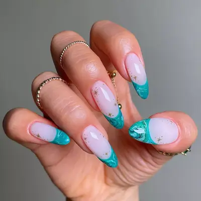 Hand with manicured nails featuring artistic designs on the tips