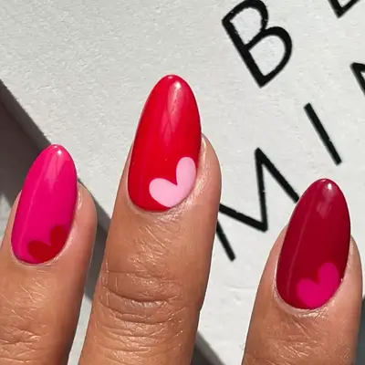 Heart accent Skittle nails with hot pink, red, burgundy, and light pink polish