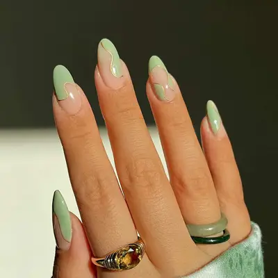 A swirly negative space manicure with sage green accents