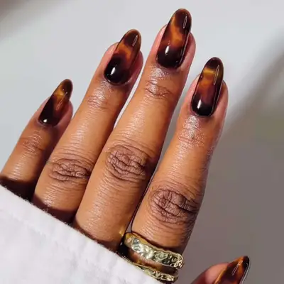 Tortoise shell manicure against a white backdrop 