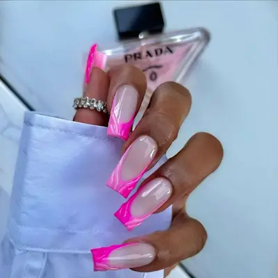 3D wavy pink ombre square French tips with a Prada perfume bottle in the background
