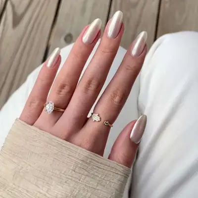 close up of hand showing off fresh manicure, milky white chrome nails