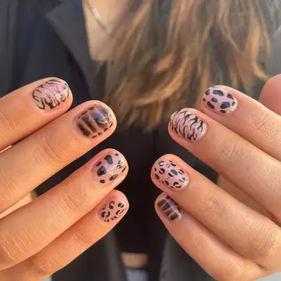 nude nails with a variety of black animal print designs