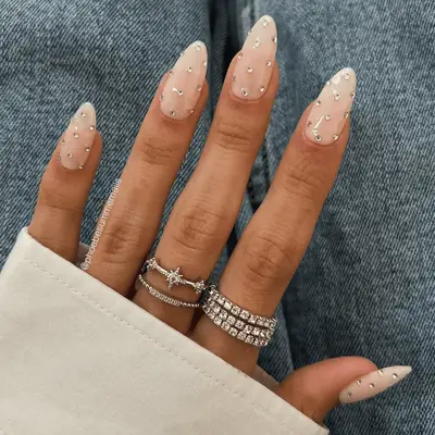 Manicured hand with rings and jeweled nails