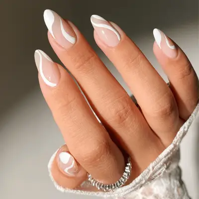 A hand with elegant white nail art designs visible