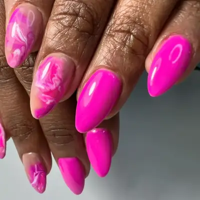 Pink watercolor manicure on short, stiletto-shaped nails.