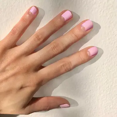Pastel pink nail design with negative space clear half moons