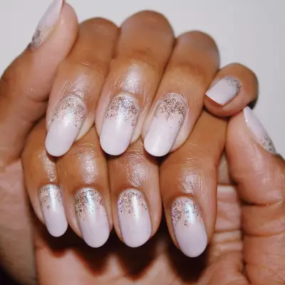Long oval-shaped nails with pink pearlescent base and glitter cuticles