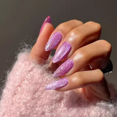 Bright pink velvet nails on long almond nails