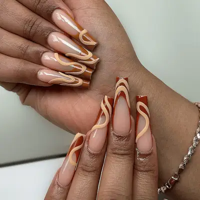 A French manicure with swirl accents in shades of brown