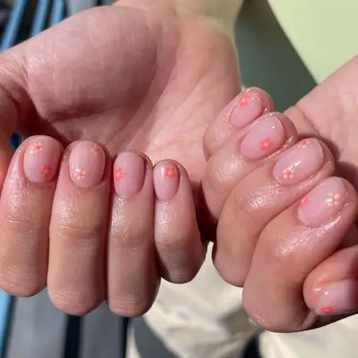 Close-up of manicure with small flower designs in shades of pink