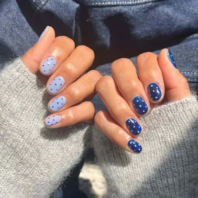 Hands with blue and white polka dotted nail design