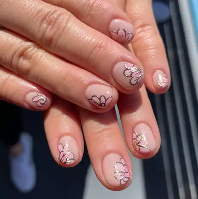 Hands with a pink floral nail design