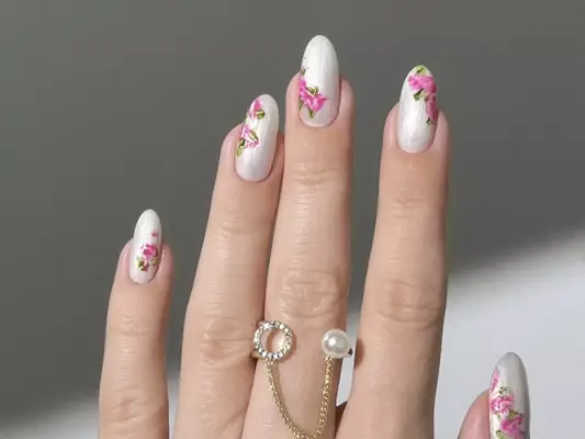 A pearly silver-white manicure with rose accents