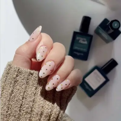 golden dot decals on pale pink nails