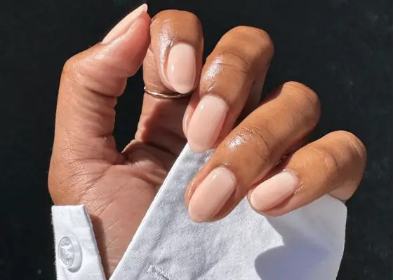 Hand with white shirt and sheer pink nails