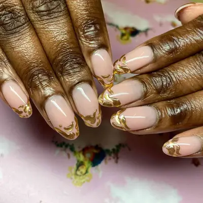 nude manicure with gold chrome accent