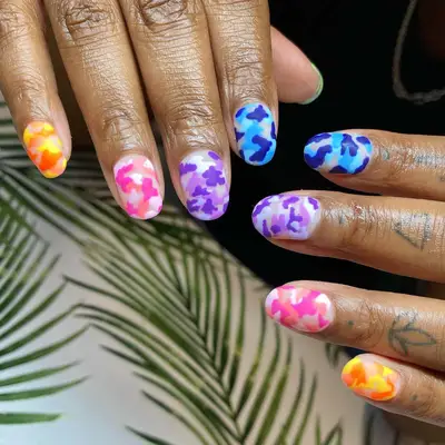 close up of nails with army print in different colors like blue, purple, pink, orange