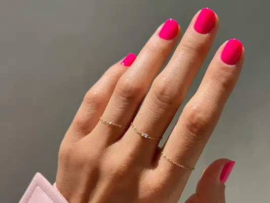 A hot pink manicure on short, squoval nails