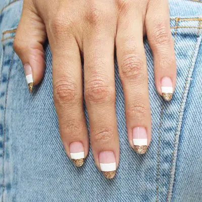 Color block manicure with rose gold tips, white center, and negative space base