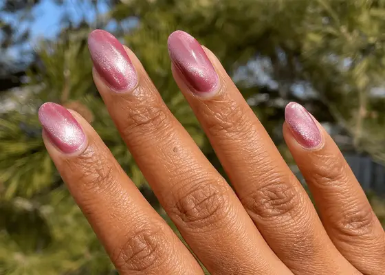 Hand with a diamond ring with rose chrome nails