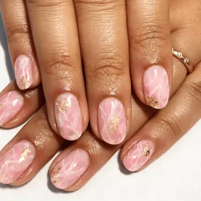 Manicure with rose quartz nail design and gold leaf on top