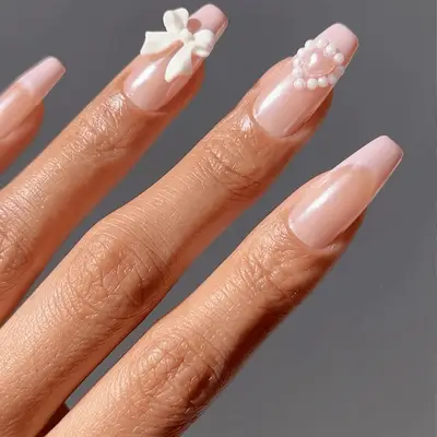 light pink french nails with heart and bow accents