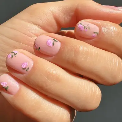 Manicure with light pink base with hand-painted pink roses on top 