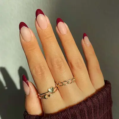 Dual-finish French manicure with neutral base and cranberry red tips