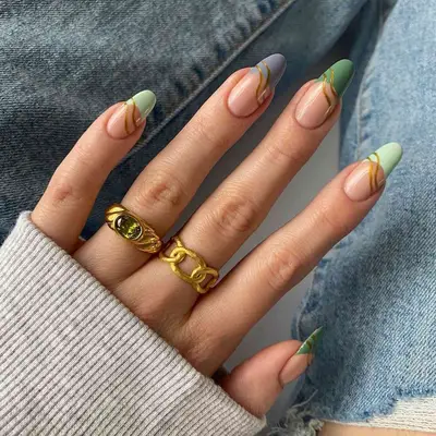 A skittle French manicure with gold details on each nai.