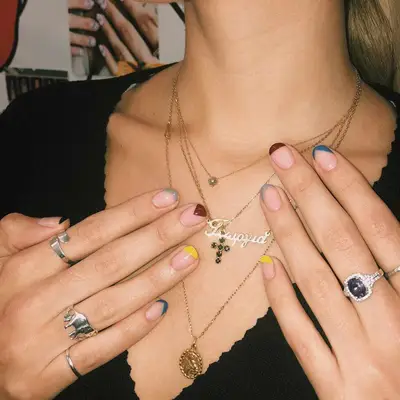 A skittle manicure with a clear base and geometric tips