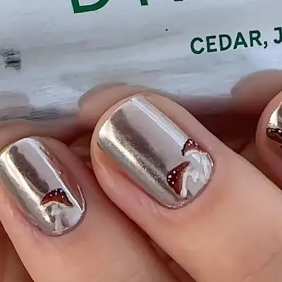 A chrome manicure with tiny mushroom accents