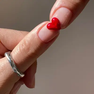Manicure with minimalist clear base and half-heart 3D design on each nail