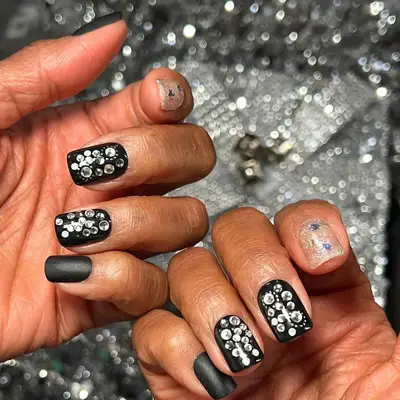 Close-up of manicure with neutral base, white French tips, and mirrored flower 3D nail design