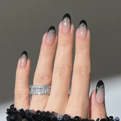 Hand with silver glitter ombre nails with stars.