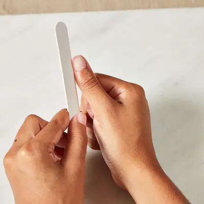 Close up of a thumb nail being filed to the side