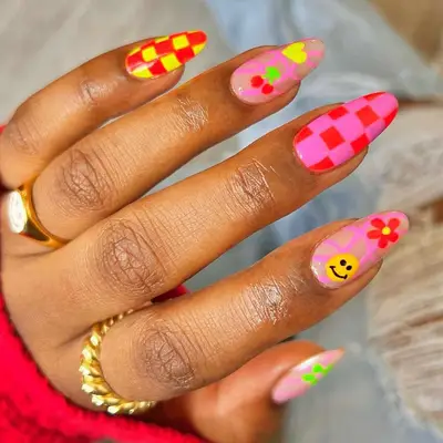 Neon tomato red mismatch nails with checkers, cherries, hearts, flowers, and smiley faces
