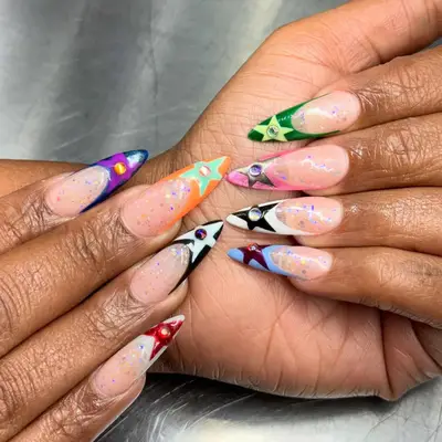 Close-up of hands with detailed nail art featuring various patterns and designs