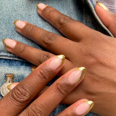 A French manicure with gold foil abstract tips