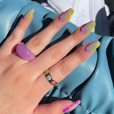 tie-dye manicure in shades of blue, purple, green, and yellow