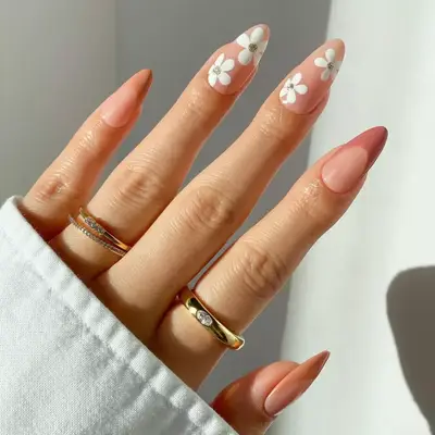 Neutral nude French manicure with floral details and rhinestones