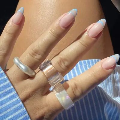 Nude almond-shaped nails with baby blue open french manicure tips