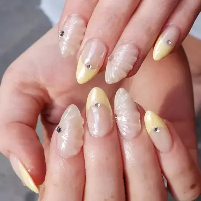 Shell-inspired yellow and neutral textured manicure