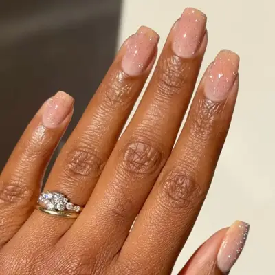 Milky nude manicure with multicolored reflective glitter