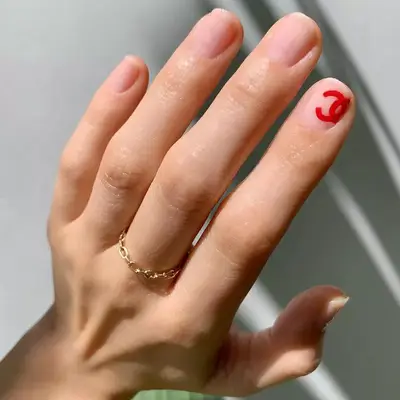 Minimal manicure with red Chanel symbol accent nails