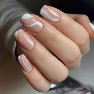 Muted dusty rose nails with white swirl designs