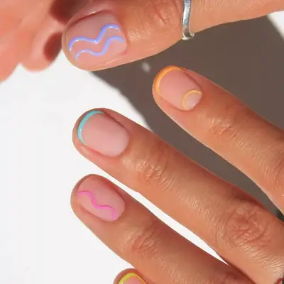 a manicure with a milky nude base topped with white swirls